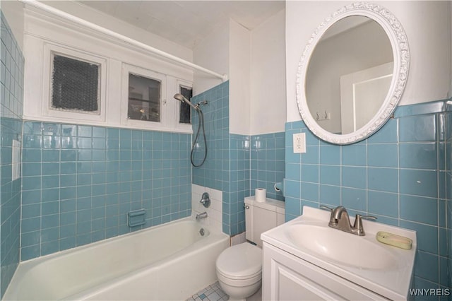 bathroom with toilet, vanity, bathtub / shower combination, and tile walls