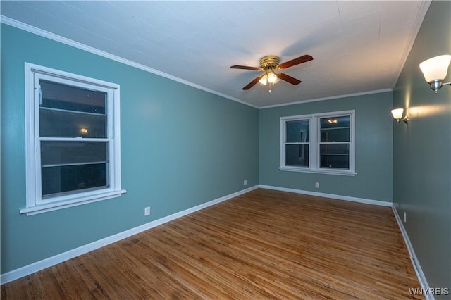 unfurnished room with ceiling fan, built in shelves, wood finished floors, baseboards, and crown molding