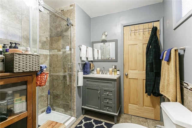 bathroom featuring a shower stall, toilet, and vanity