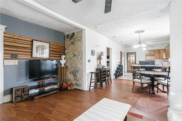 living area with a textured ceiling, wood finished floors, and a notable chandelier