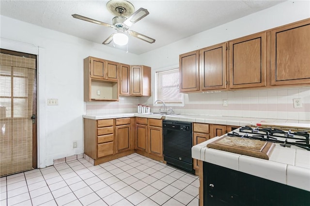 kitchen featuring brown cabinetry, black dishwasher, a sink, and decorative backsplash