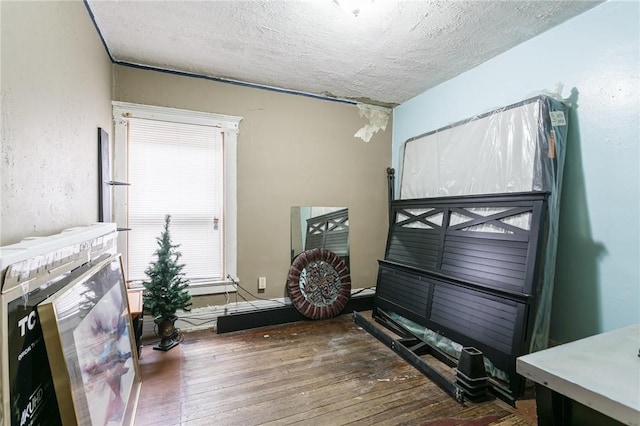 interior space with a textured ceiling and hardwood / wood-style flooring