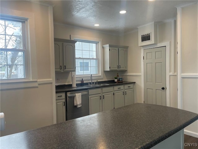 kitchen with a sink, dark countertops, a healthy amount of sunlight, and dishwasher