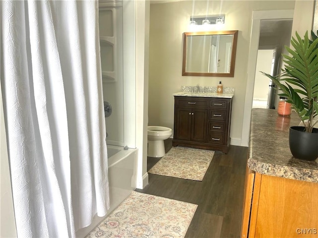 full bath with toilet, shower / tub combo, wood finished floors, and vanity