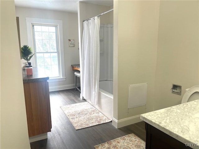 full bath with wood finished floors, vanity, and baseboards