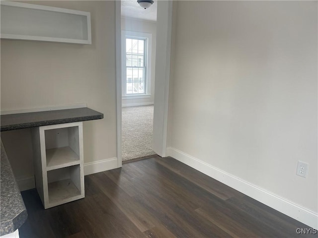 interior space with baseboards and dark wood finished floors