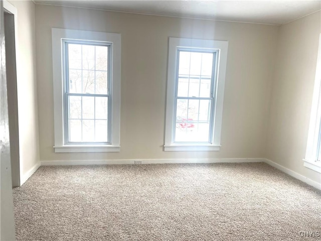 unfurnished room with carpet floors, a wealth of natural light, and baseboards