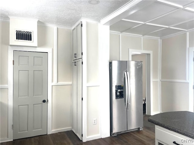 kitchen featuring a textured ceiling, visible vents, stainless steel refrigerator with ice dispenser, dark countertops, and dark wood finished floors