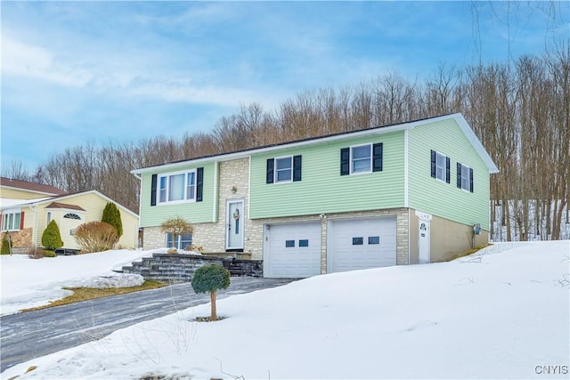 bi-level home featuring stone siding and an attached garage