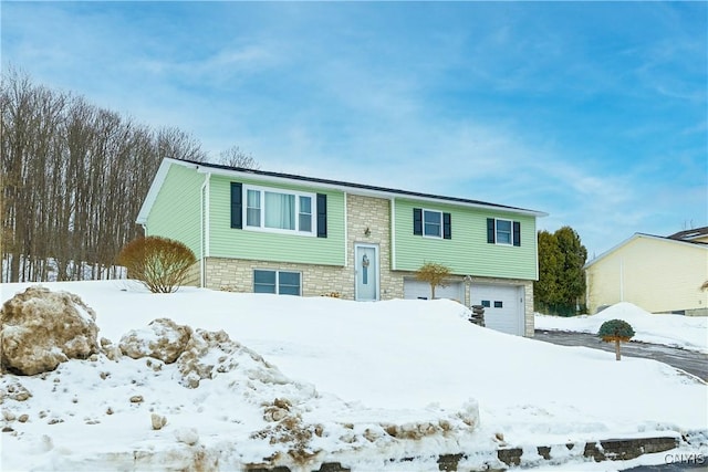 split foyer home featuring stone siding and an attached garage