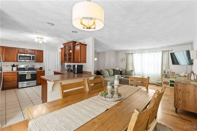 dining space featuring light wood-style flooring and an inviting chandelier