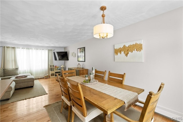 dining room with light wood-style floors and a baseboard radiator