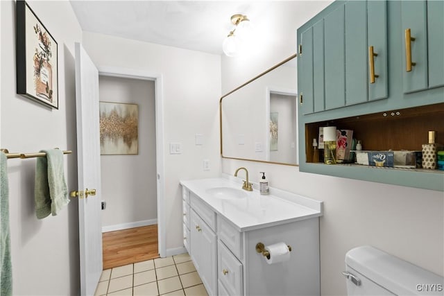 bathroom featuring baseboards, vanity, toilet, and tile patterned floors