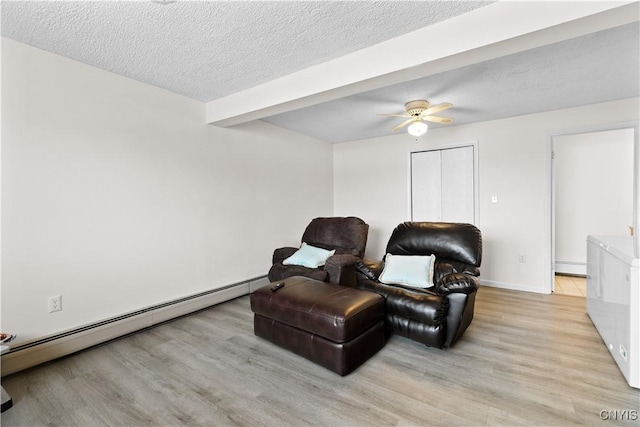 sitting room featuring a baseboard heating unit, a textured ceiling, light wood-style flooring, and a ceiling fan