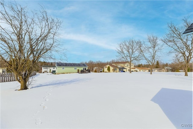 yard covered in snow featuring fence