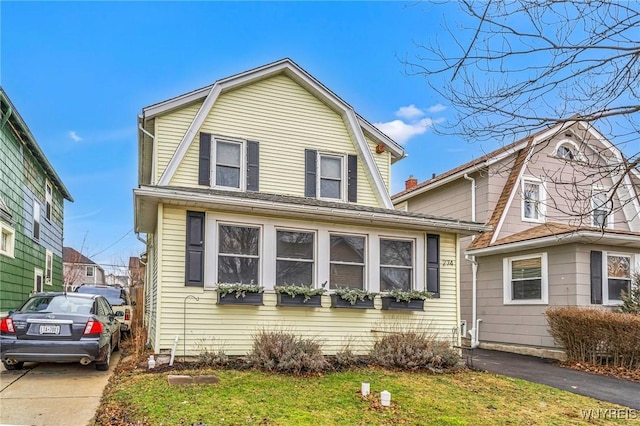 dutch colonial featuring driveway and a gambrel roof