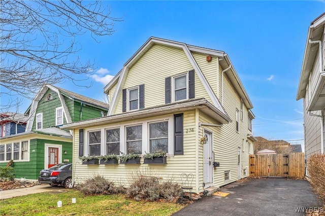 colonial inspired home with a gate and a gambrel roof