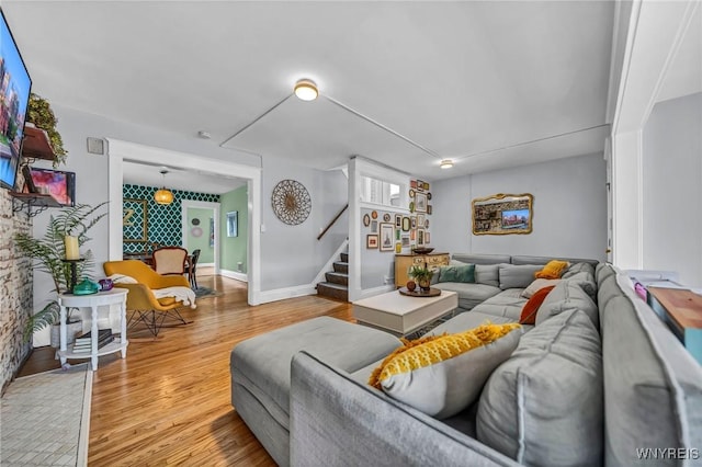 living area featuring wood finished floors, baseboards, and stairs