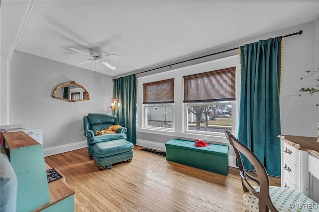 living area featuring visible vents, a ceiling fan, hardwood / wood-style flooring, and baseboards