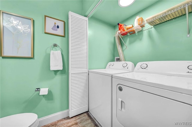 clothes washing area featuring laundry area, light wood finished floors, independent washer and dryer, and baseboards