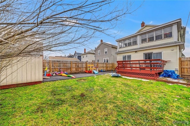 view of yard featuring a patio, a storage shed, a deck, a fenced backyard, and an outdoor structure