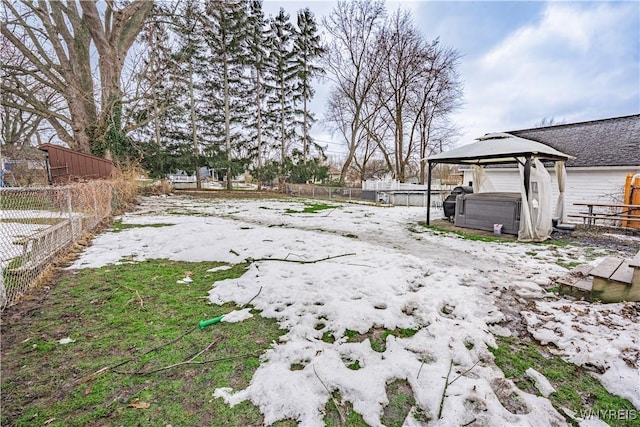 view of yard featuring a hot tub, a fenced backyard, and a gazebo