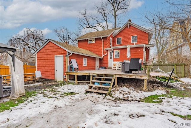 back of house with fence, a chimney, and a wooden deck