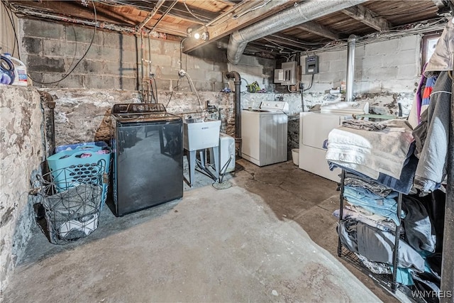 unfinished below grade area with electric panel, separate washer and dryer, and a sink