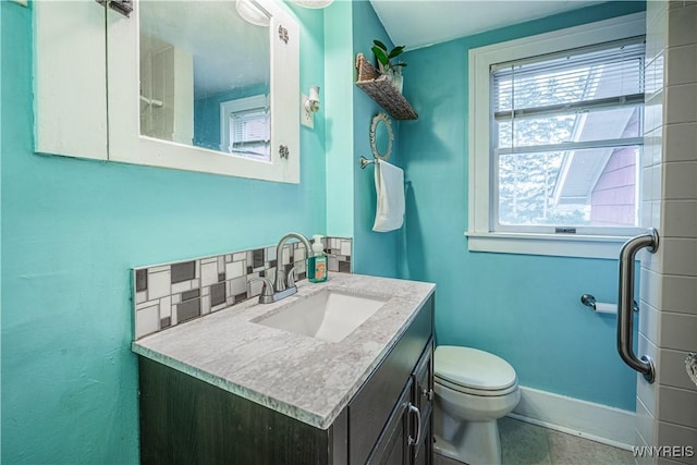 bathroom featuring toilet, baseboards, and vanity