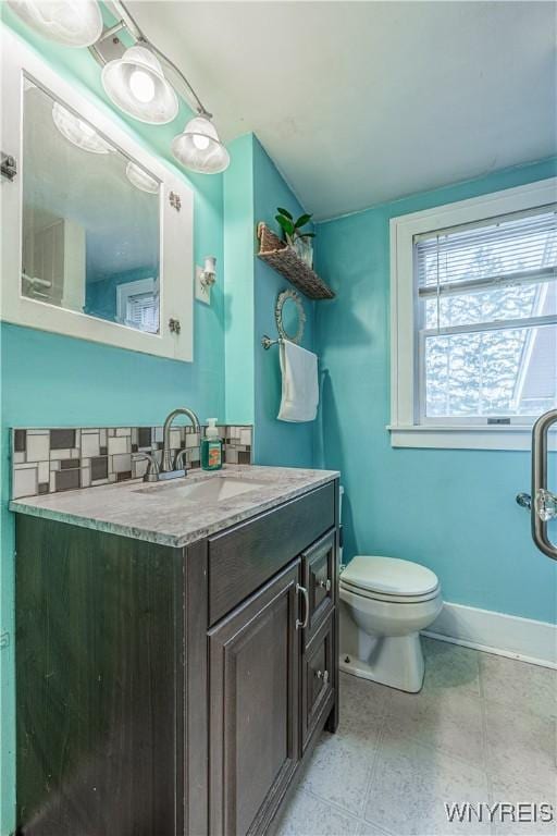 bathroom with vanity, toilet, and baseboards