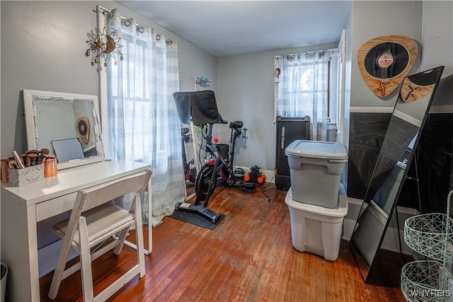 exercise area with baseboards and wood finished floors