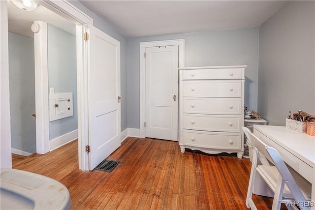 bedroom featuring wood-type flooring, visible vents, and baseboards