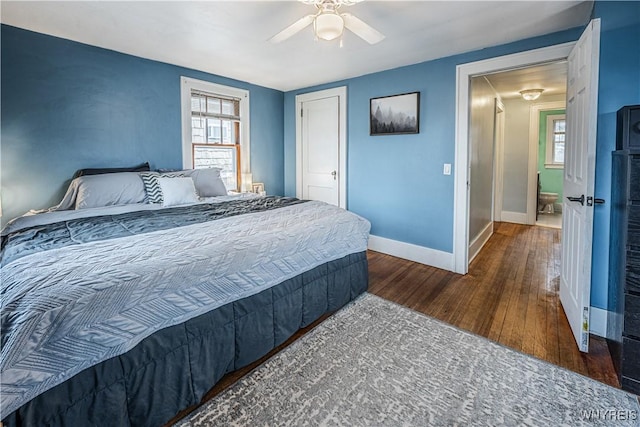 bedroom featuring a ceiling fan, multiple windows, baseboards, and hardwood / wood-style flooring