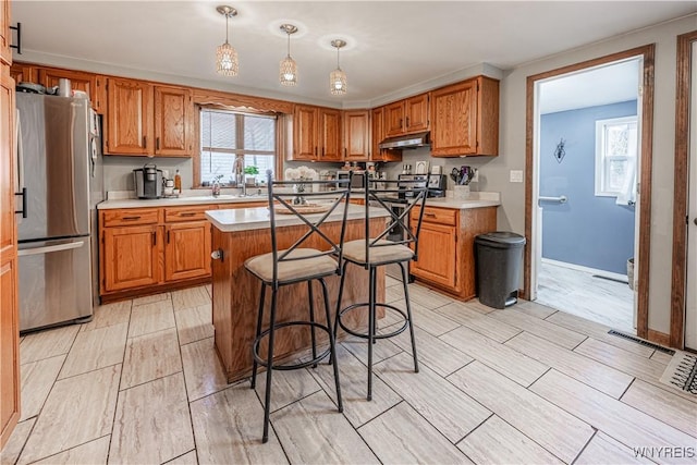 kitchen with freestanding refrigerator and brown cabinets