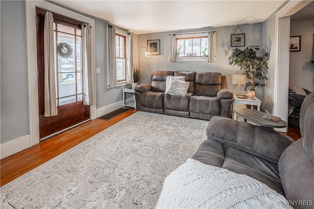 living area with wood finished floors, visible vents, and baseboards