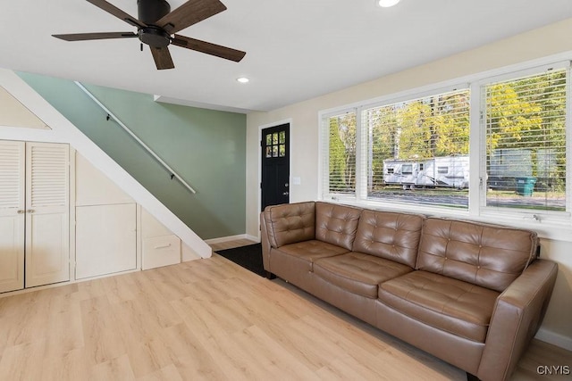 living room with recessed lighting, wood finished floors, a ceiling fan, baseboards, and stairs