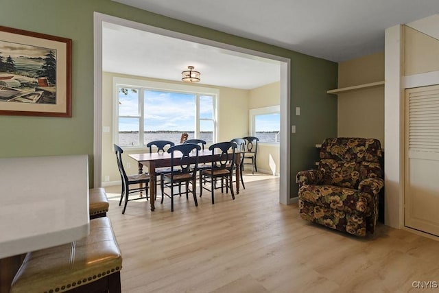 dining space with light wood-style floors and baseboards