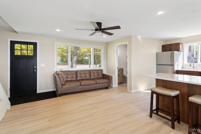 living room with baseboards, recessed lighting, and light wood-style floors