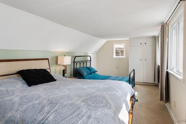 carpeted bedroom featuring baseboards, vaulted ceiling, and a closet