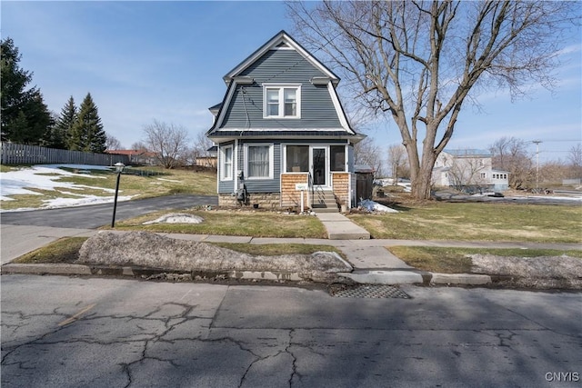 view of front of house with a front yard, fence, and a gambrel roof