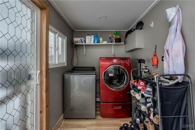 clothes washing area featuring laundry area, washing machine and clothes dryer, and wood finished floors