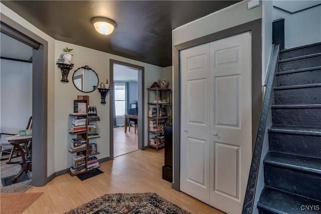 interior space with stairs, light wood-type flooring, and baseboards