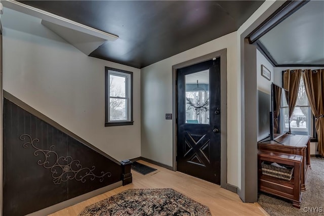 foyer with a chandelier, baseboards, and light wood-style floors