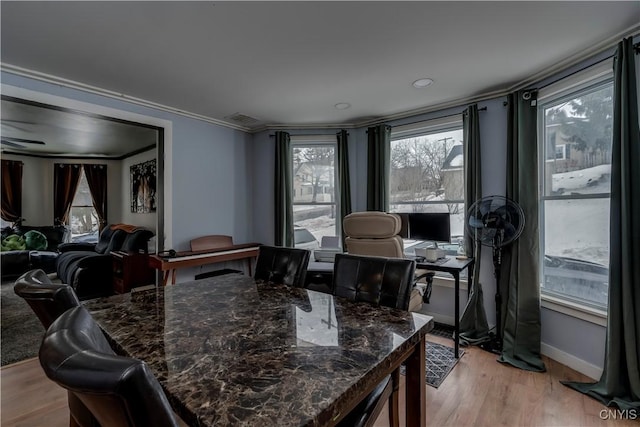 dining space with light wood-style floors, visible vents, ornamental molding, and baseboards