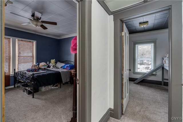 bedroom featuring baseboards, ornamental molding, ceiling fan, and carpet flooring