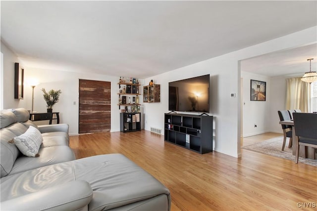 living room with light wood-type flooring and visible vents