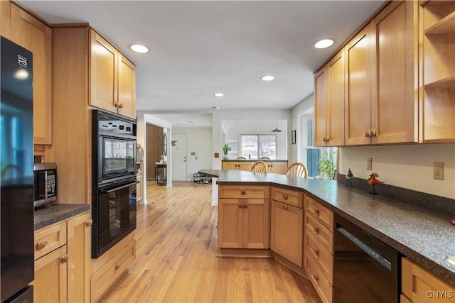 kitchen with light wood-style flooring, a peninsula, black appliances, open shelves, and dark countertops