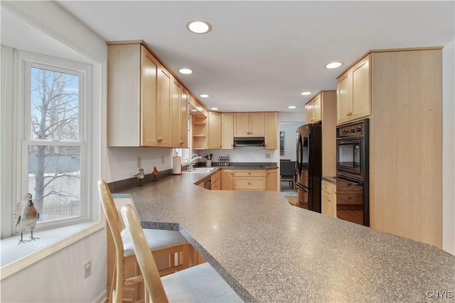 kitchen with freestanding refrigerator, light brown cabinets, a sink, oven, and under cabinet range hood