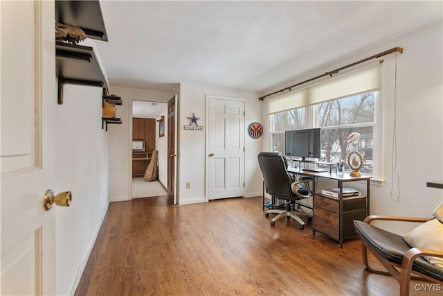 home office with baseboards and wood finished floors