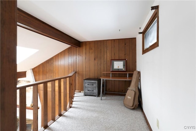 hallway featuring vaulted ceiling with beams, carpet floors, and wooden walls